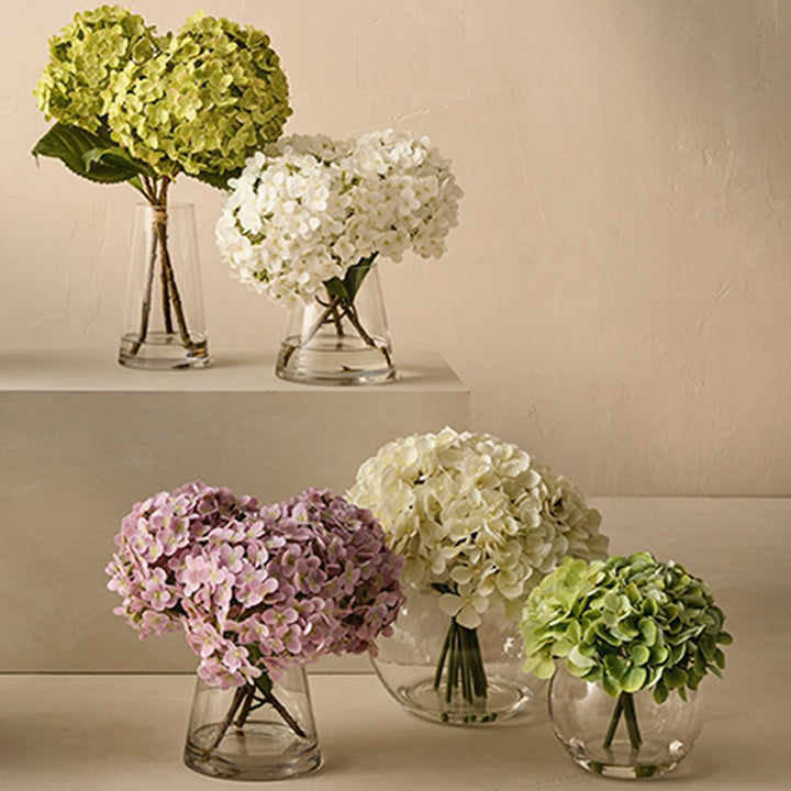 Artificial white hydrangeas in large round glass vase – view 3